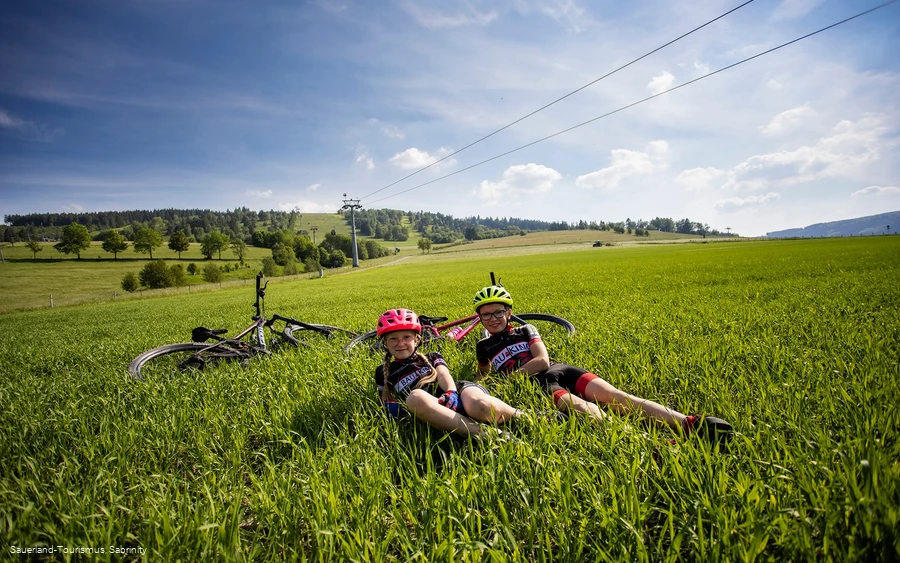 Kinder mit Bikes im Gras an der Talstation der Ettelsberg-Seilbahn 