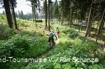 3 Mountainbiker fahren einen Trail hinab